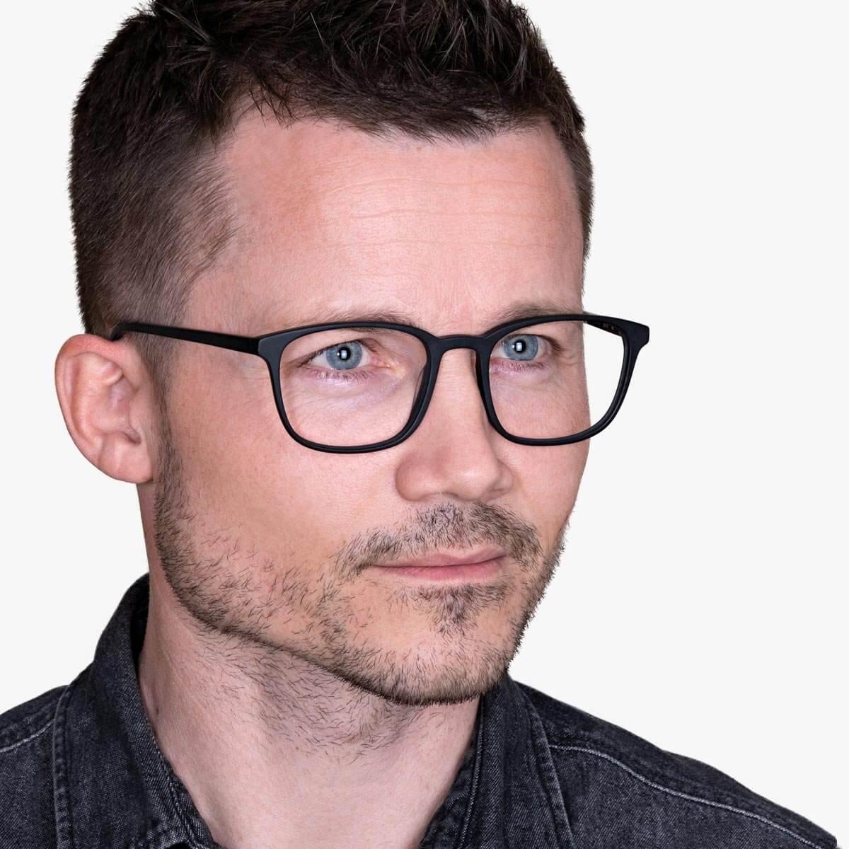 Person wearing Ebeltoft Black glasses with black frames