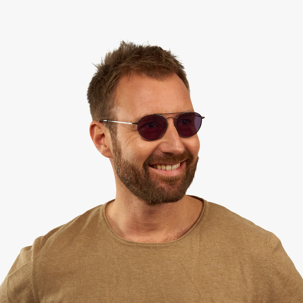 Person wearing Göteborg Gun sunglasses with gold frame and dark lenses